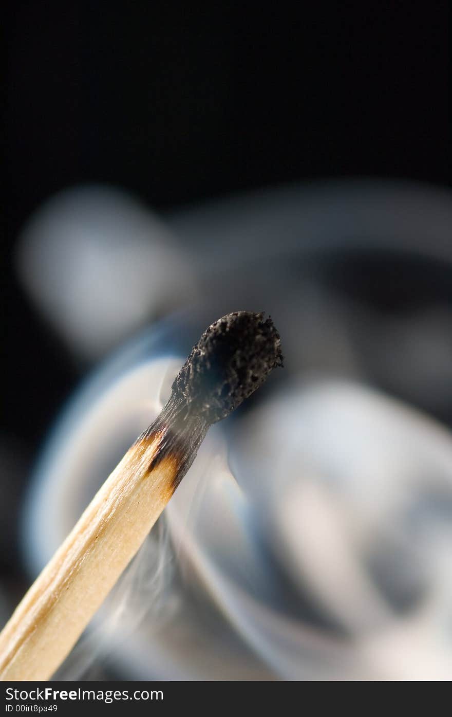 Close up of a smoking match on a black background