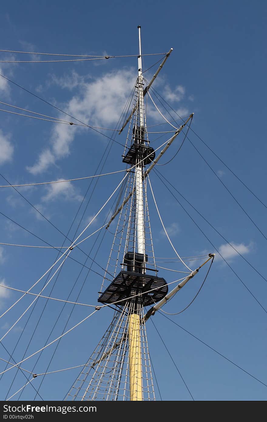 Mast of ship on blue sky and clouds background