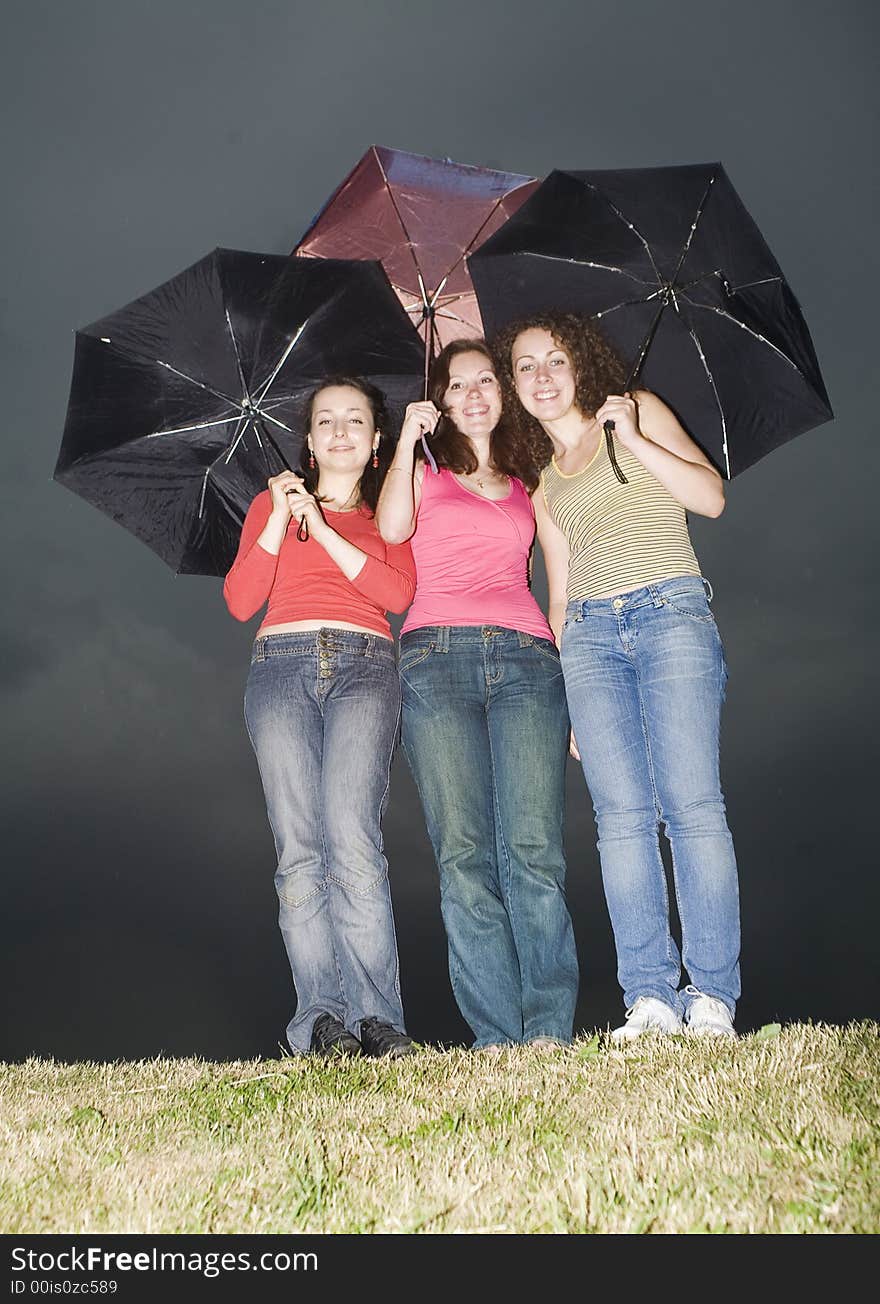 Three girls with colored umbrellas. Three girls with colored umbrellas