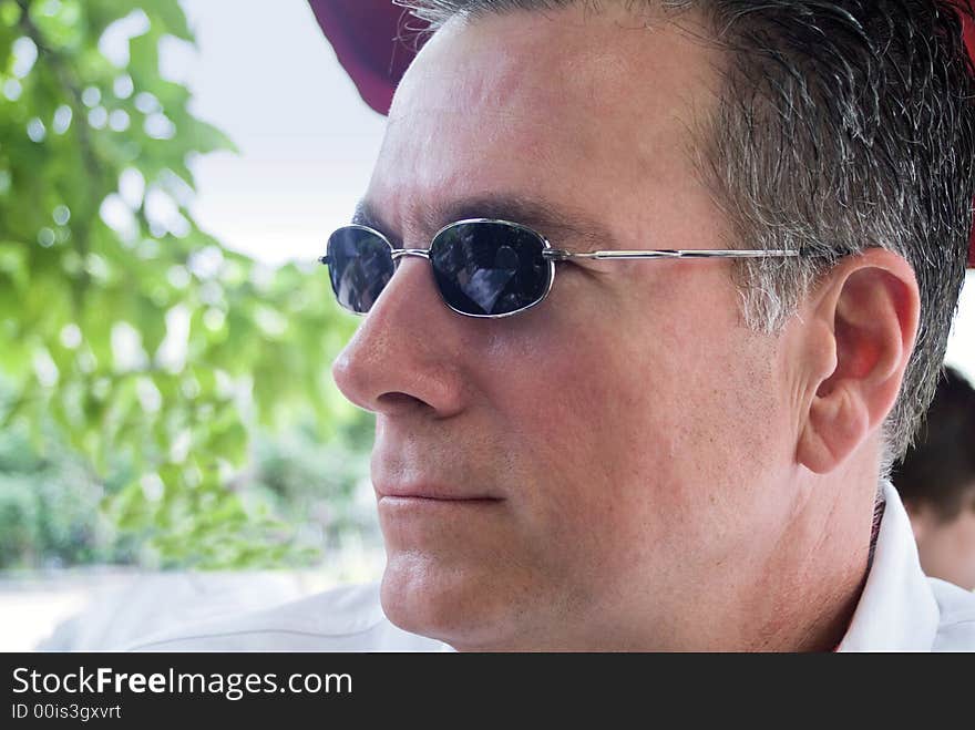 A man with sunglasses on lunching at an outside cafe. A man with sunglasses on lunching at an outside cafe.