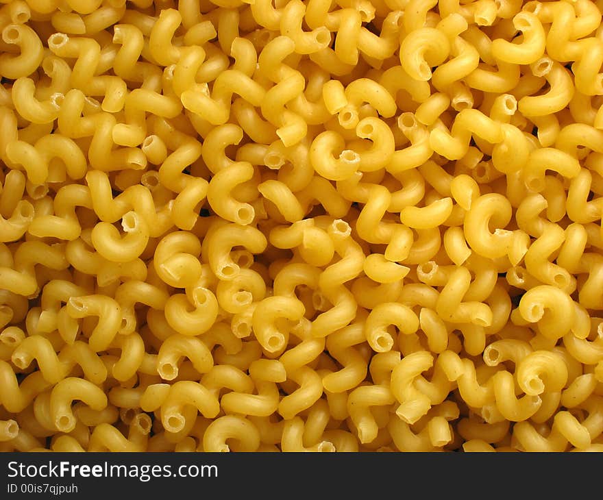 Backgrounds. Heap of raw golden macaroni-spiral