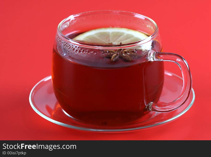 Cup of tea with anise lemon on red background