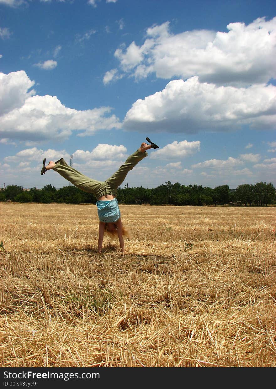 Young woman in yellow field do handsprings. Young woman in yellow field do handsprings