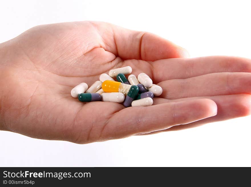 A hand holds a variety of colorful pills. A hand holds a variety of colorful pills.