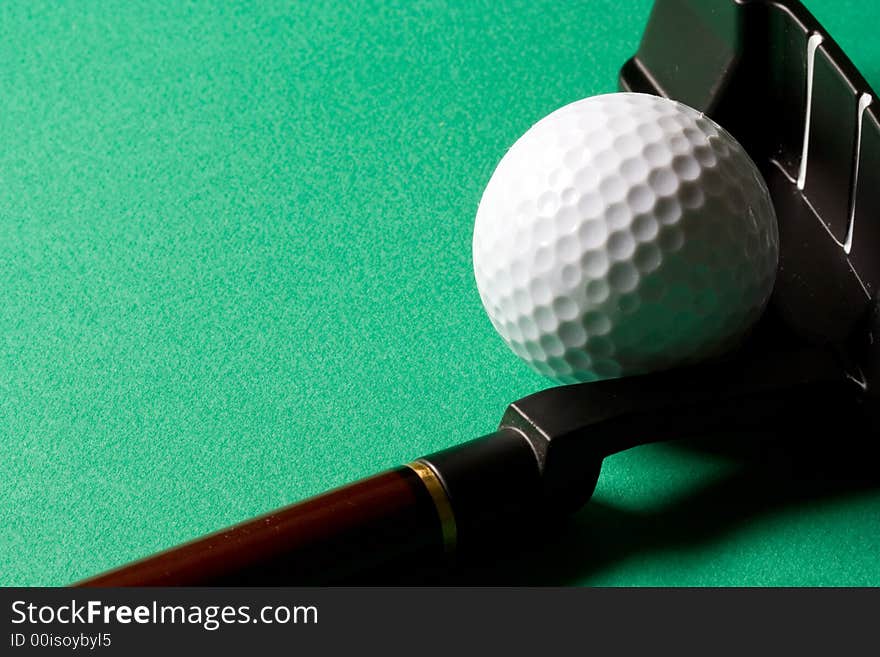 Golf club and ball on green background