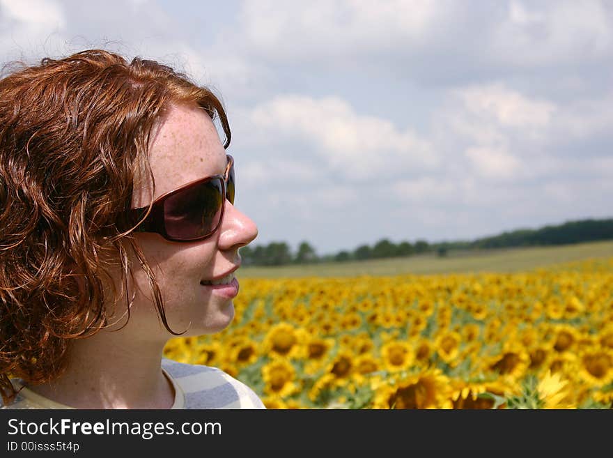 A young lady standing in a field of sunflowers. A young lady standing in a field of sunflowers