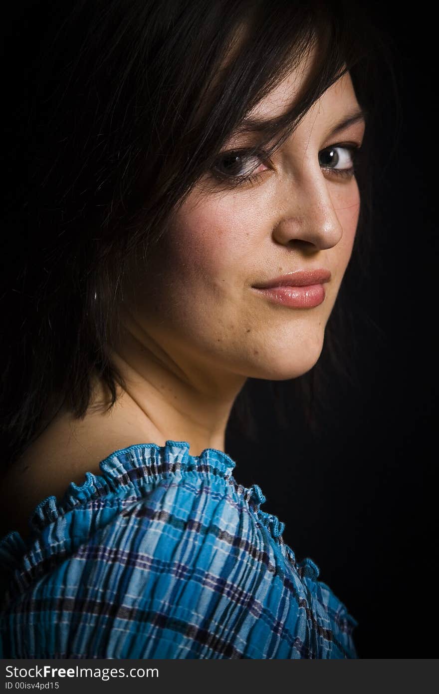 Beautiful young woman against a black background