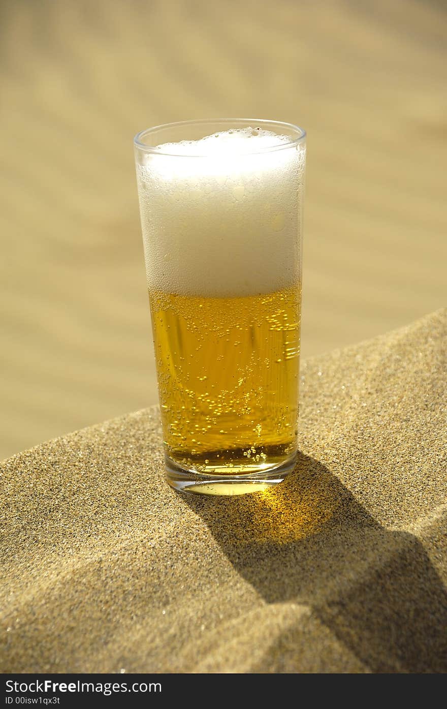 A glass of fresh beer in a desert. A glass of fresh beer in a desert.