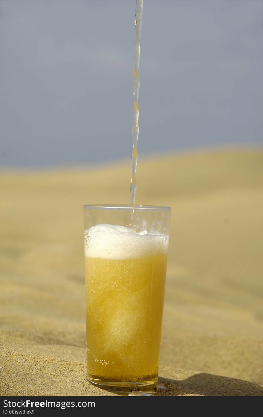 A glass of fresh beer in a desert. A glass of fresh beer in a desert.