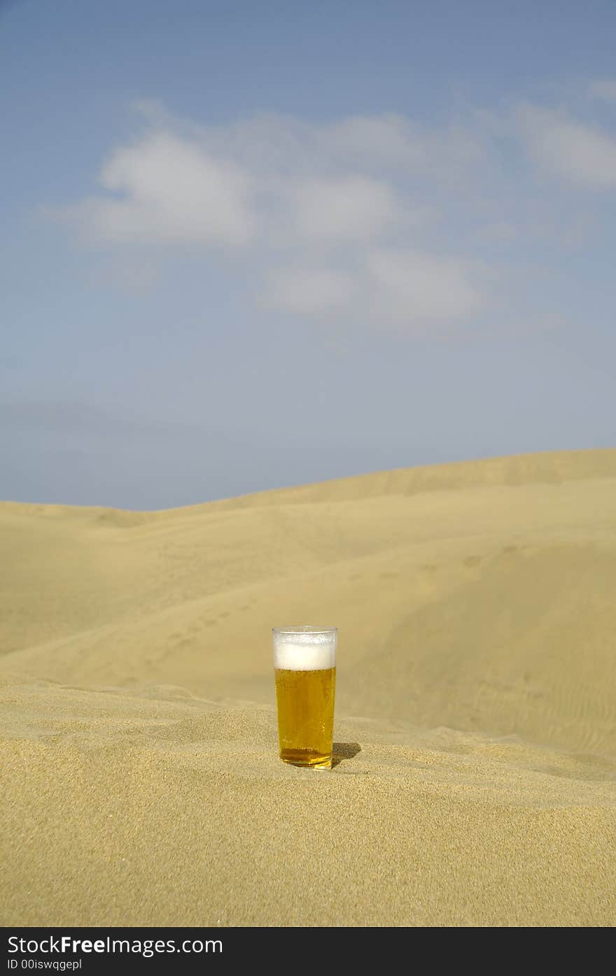 A glass of fresh beer in a desert. A glass of fresh beer in a desert.