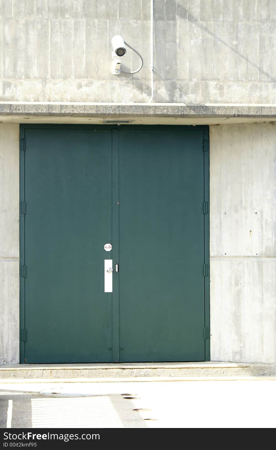 A security camera above an entrance door. A security camera above an entrance door