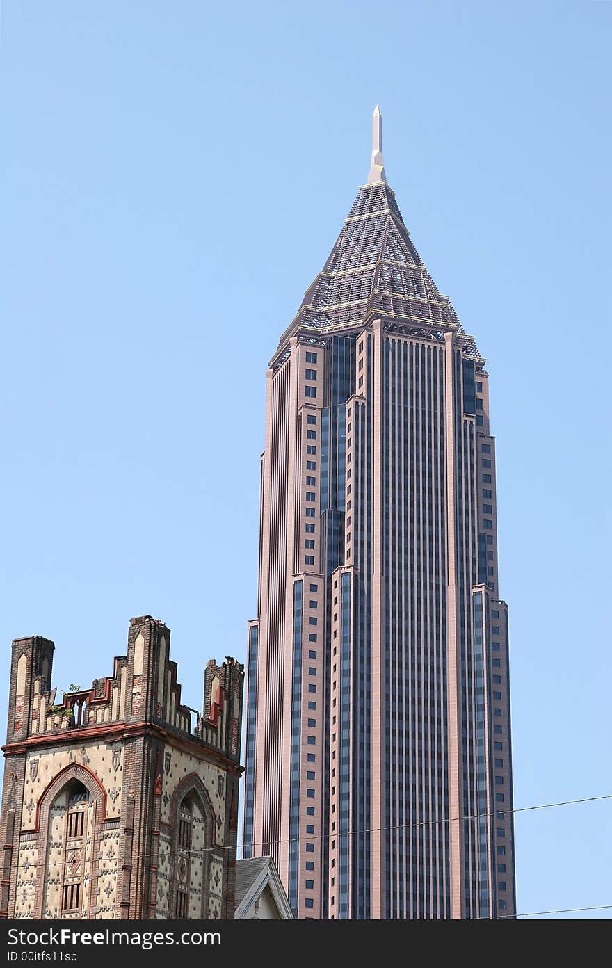 A modern office tower with an old church tower in the foreground. A modern office tower with an old church tower in the foreground