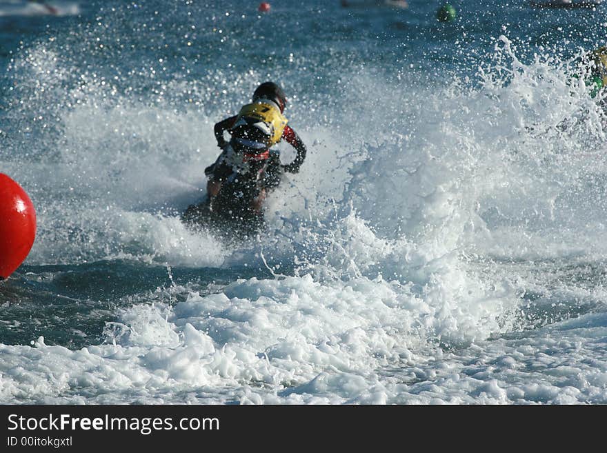 Young man speeding on jet ski making a big splash. Young man speeding on jet ski making a big splash