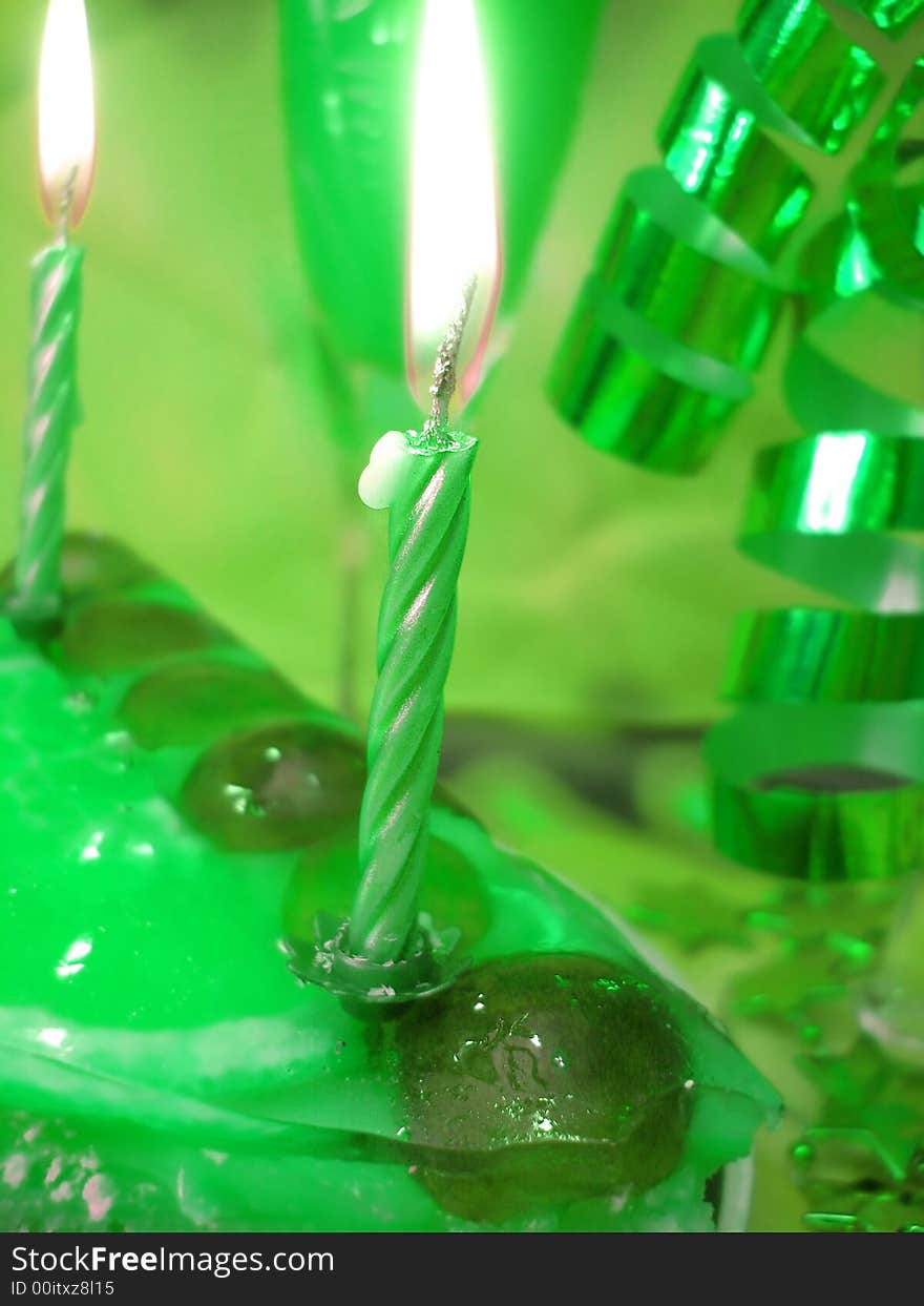 Cake and candles on green background