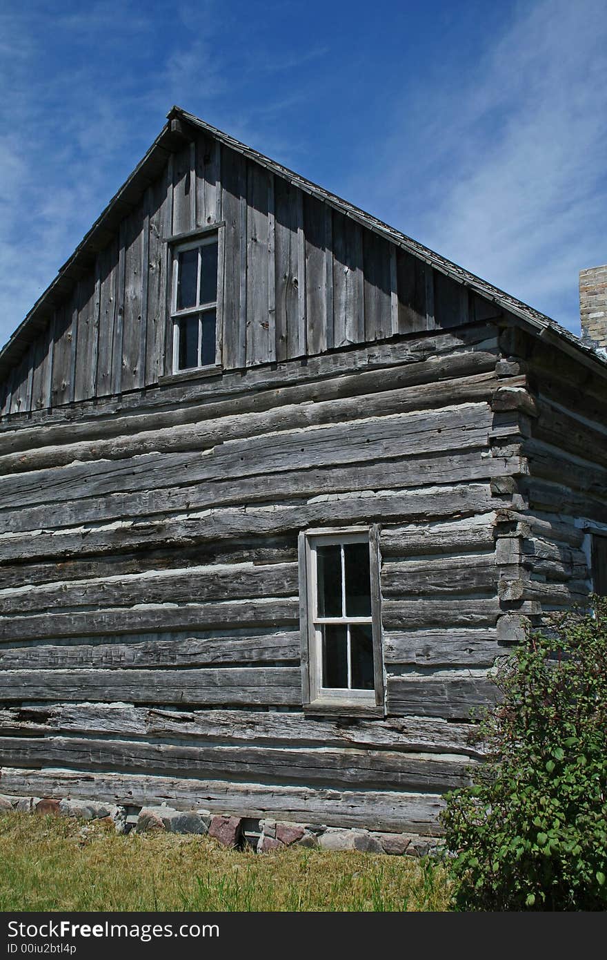 A settler's log cabin - side wall with blue sky.