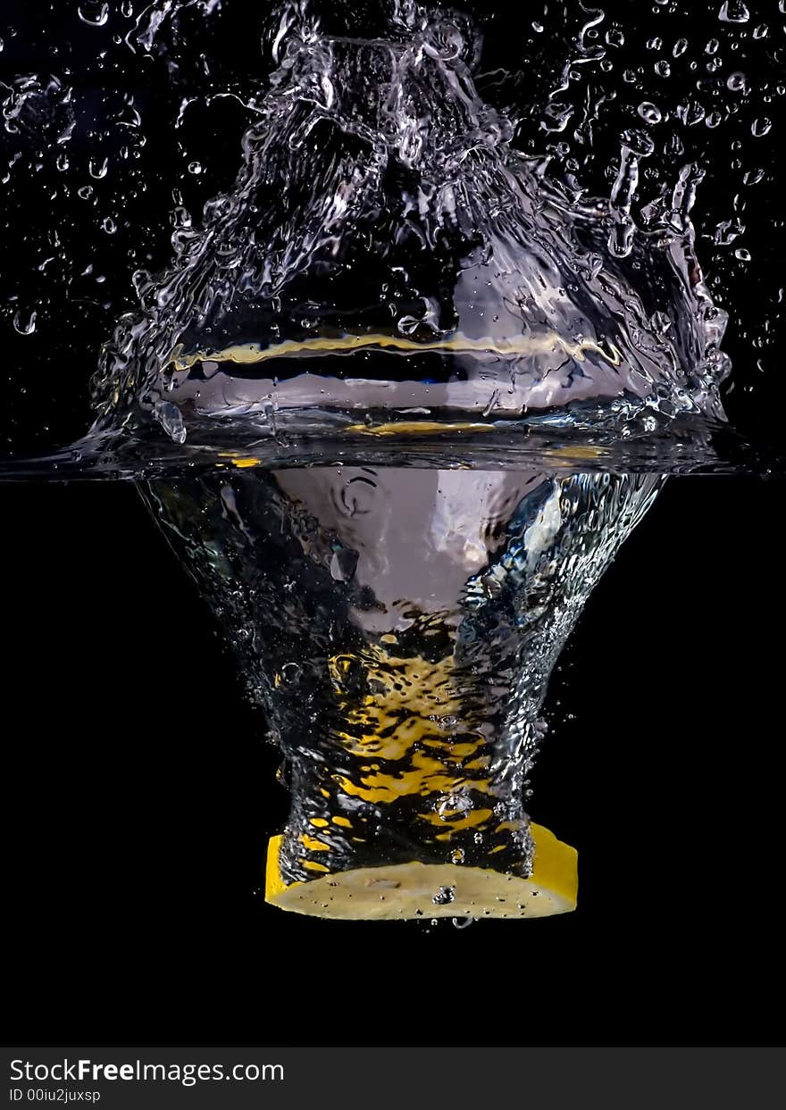 Splashing lemon into the water over black background