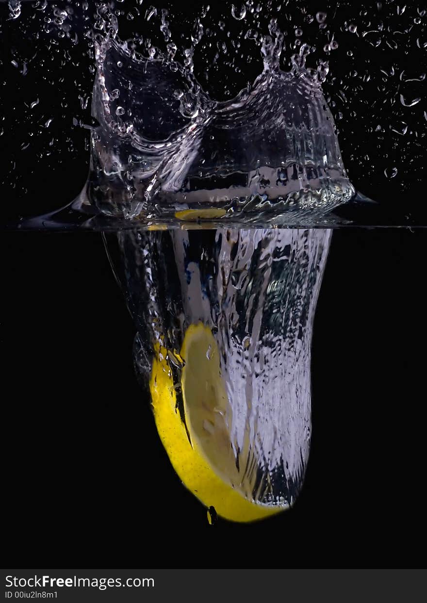 Splashing lemon into the water over black background