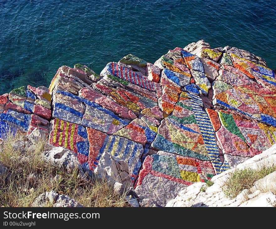 Colorful painted rock and blue sea