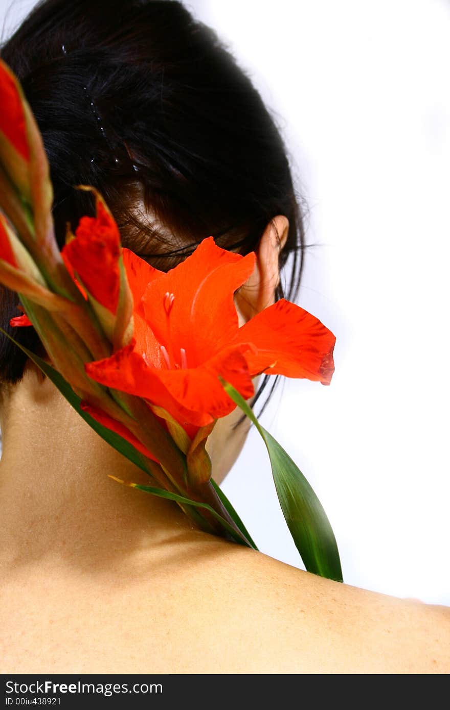 Back of a young woman with a flower and black hair. Back of a young woman with a flower and black hair