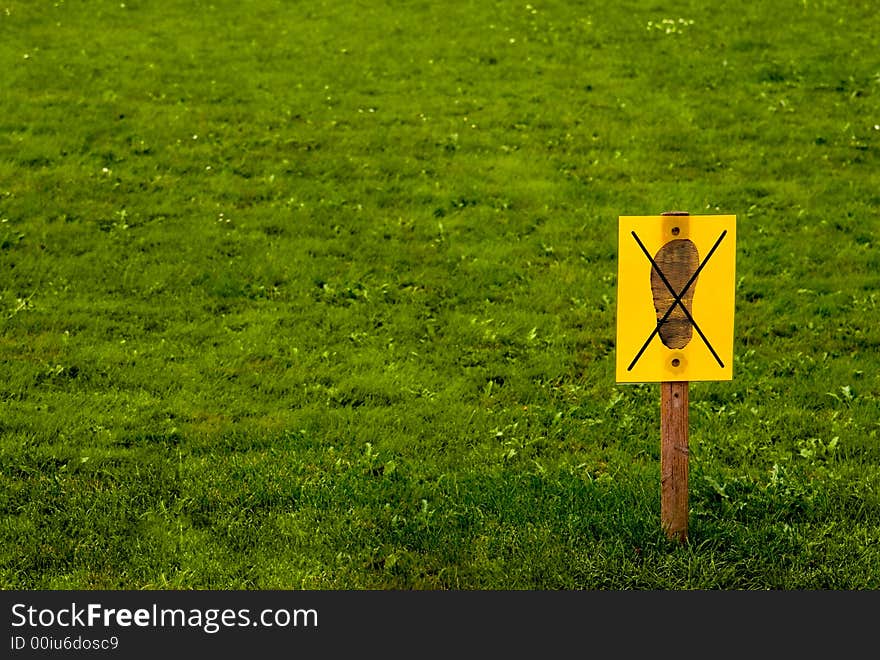 "Do not enter" yellow sign on grass background. "Do not enter" yellow sign on grass background