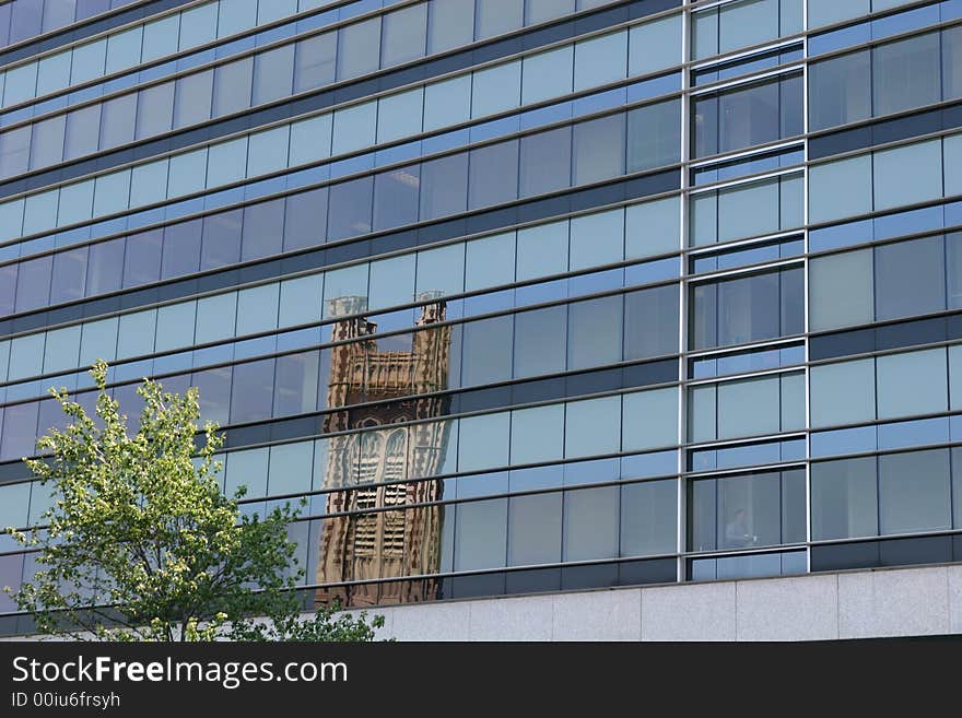 A blue glass office building with a church tower reflected. A blue glass office building with a church tower reflected