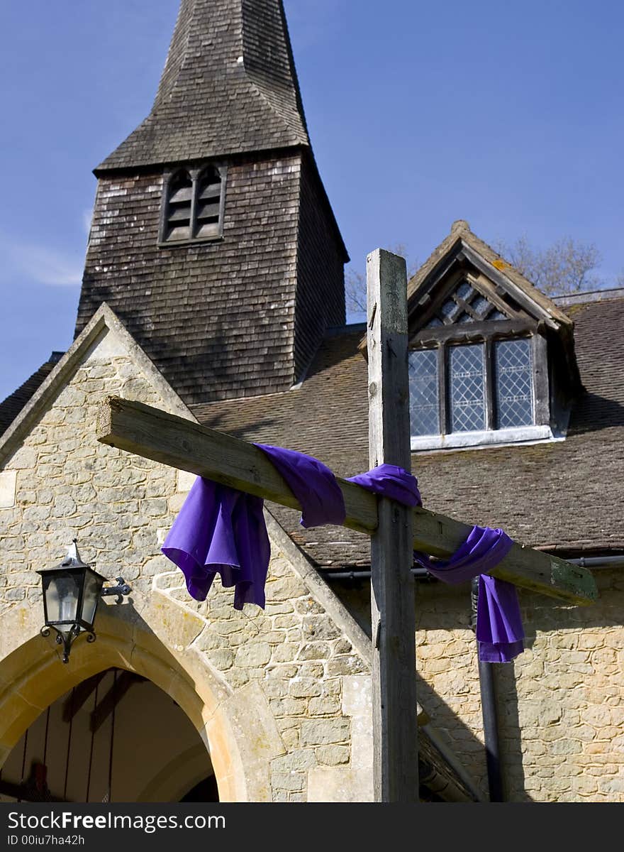 A cross in front of an old church. A cross in front of an old church