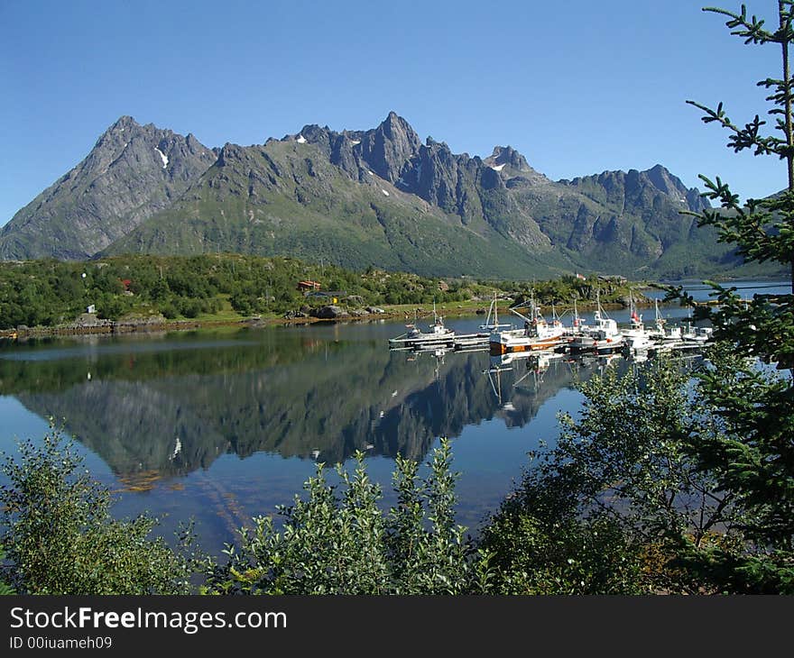 Picturesque small marina under the mountains. reflection of yachts in the water. Picturesque small marina under the mountains. reflection of yachts in the water.