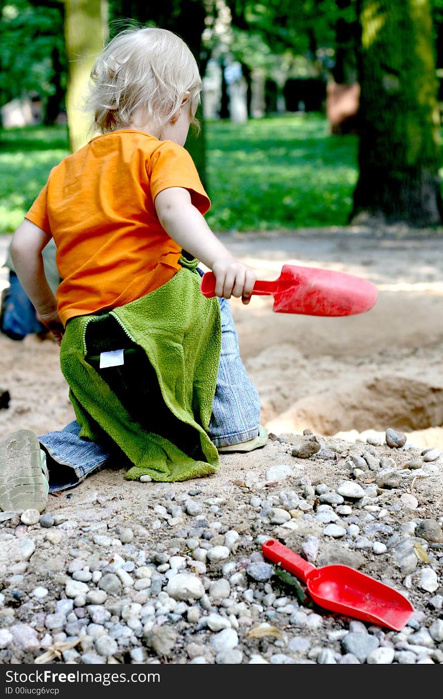 Baby girl playing with sand in the park. Baby girl playing with sand in the park