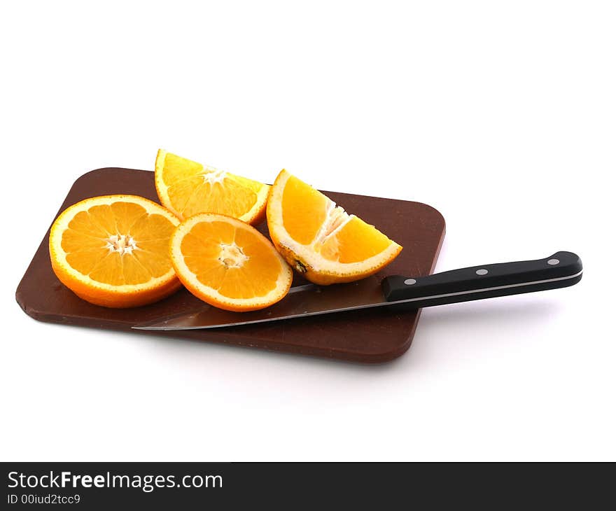 Slices of an orange and knife on a chopping board. Isolate on white