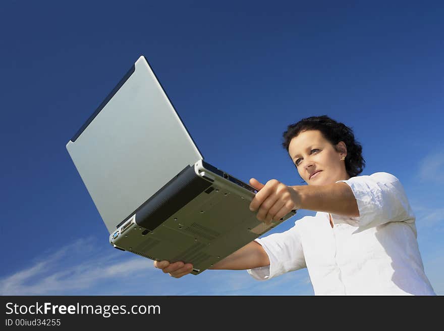 View of nice young woman with laptop on blue back. View of nice young woman with laptop on blue back