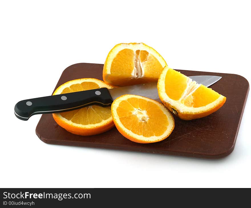 Slices of an orange and knife on a chopping board. Isolate on white