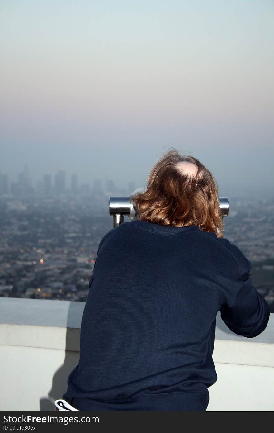 Man looking at LA through Coin Operated Binoculars