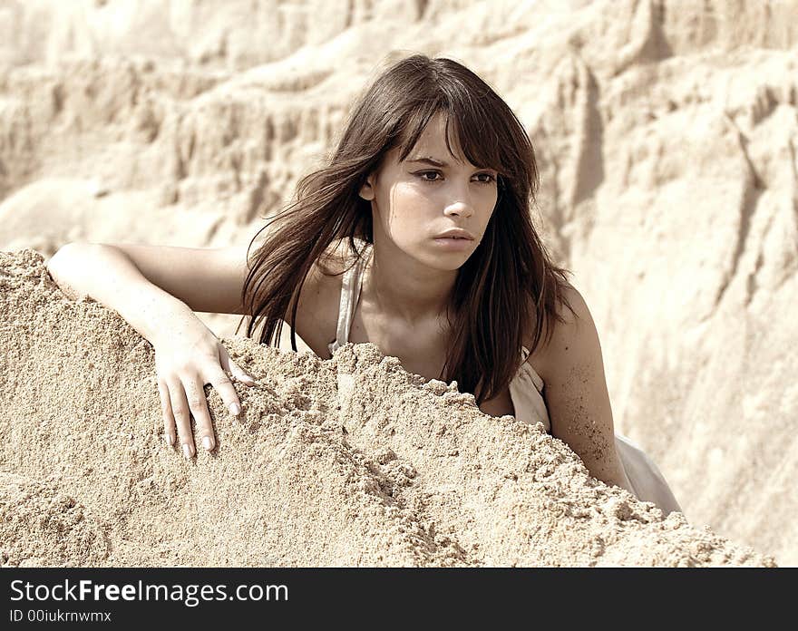 Portrait of the young beautiful woman on a background of sand. Portrait of the young beautiful woman on a background of sand