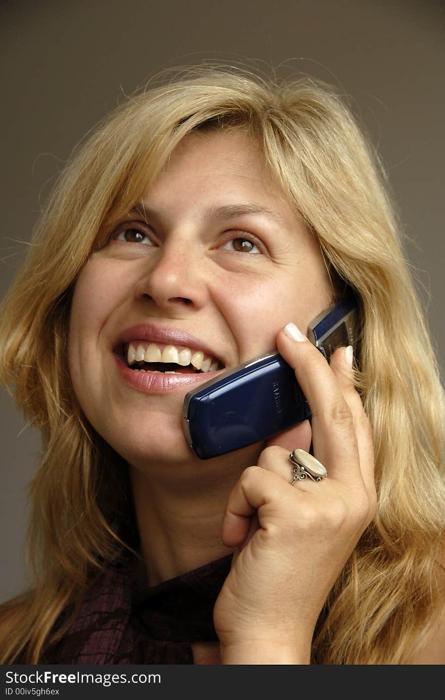 A blonde is talking on the phone. A blonde is talking on the phone