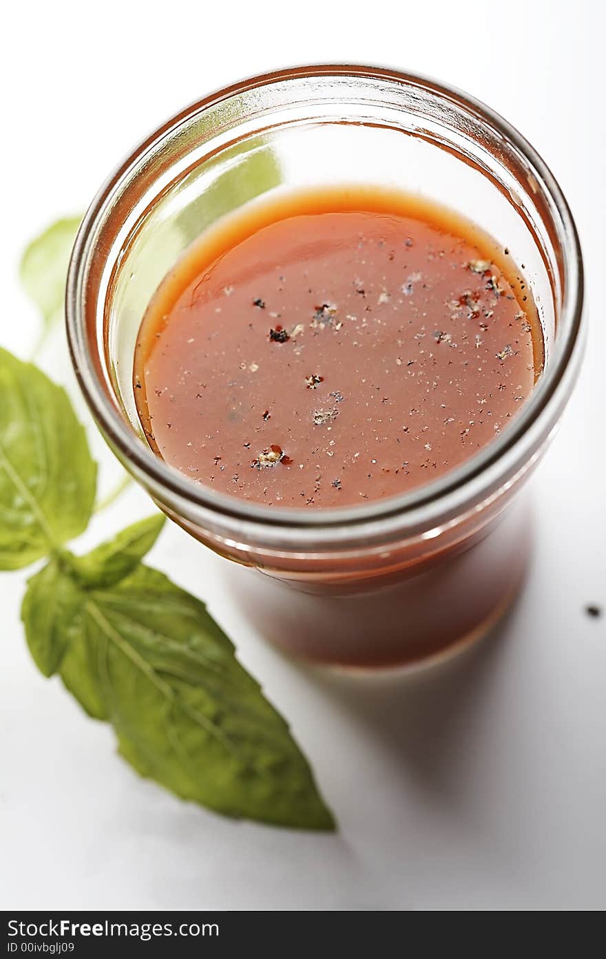 Tomato juice with sweet basil on white background