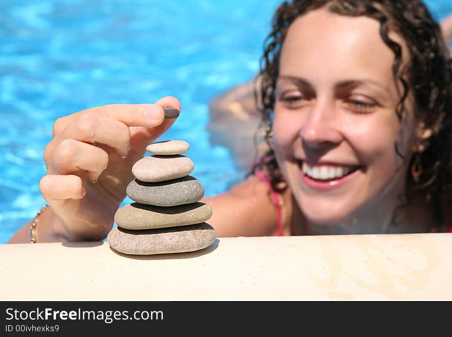 The woman builds a figure of stones about water. The woman builds a figure of stones about water