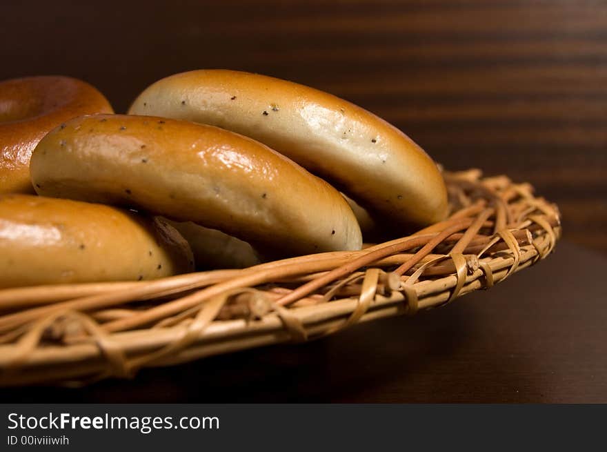 Appetizing bagels on wicker plate at the table