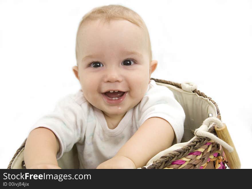 Cute and happy baby boy sitting in a basket