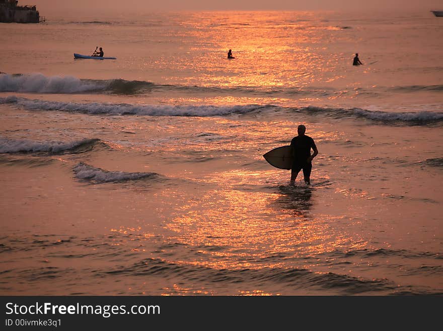 Sihoulettes of surfers in surf