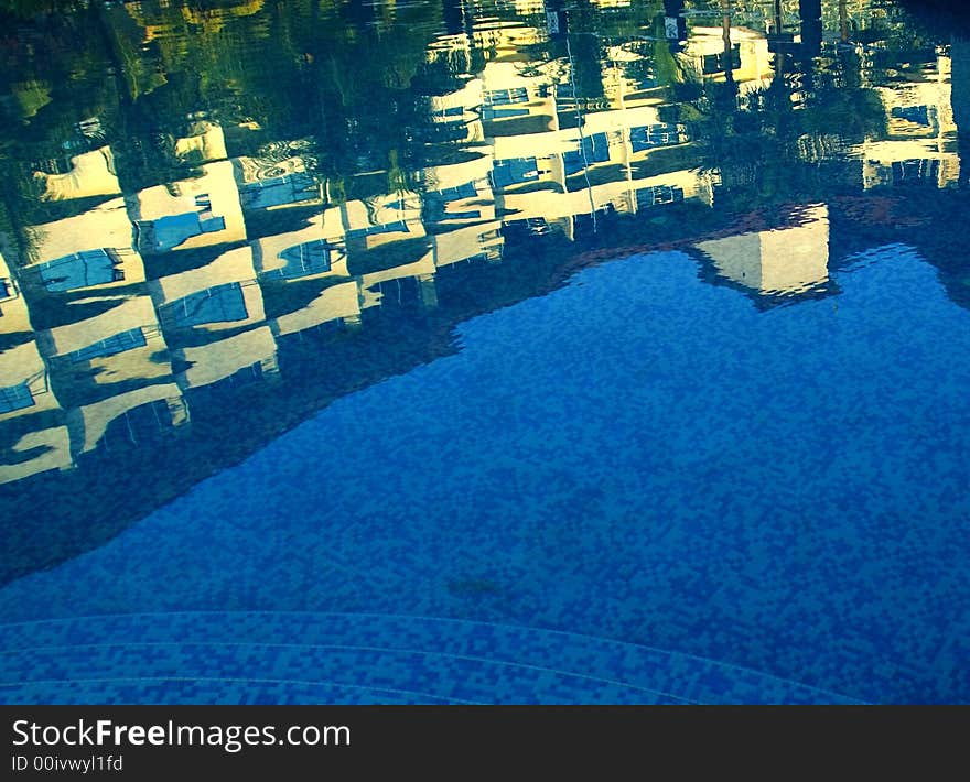 a resort hotel by a beach with large  free format pool .

a reflection of a modern five star hotel