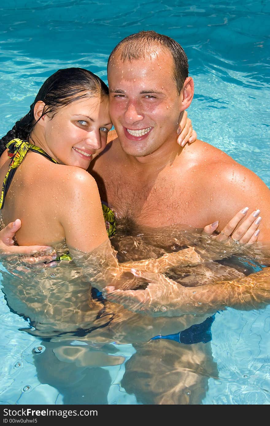 An attractive young couple relaxing by the pool. An attractive young couple relaxing by the pool