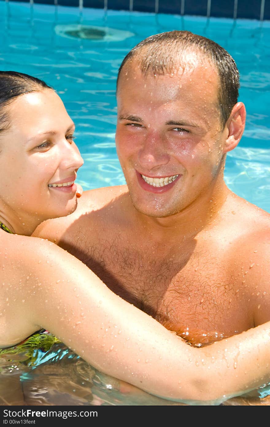 An attractive young couple relaxing by the pool. An attractive young couple relaxing by the pool