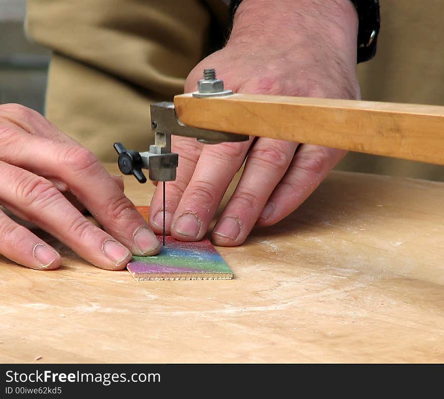 Peddler using foot powered jigsaw machine to cut names. Peddler using foot powered jigsaw machine to cut names.