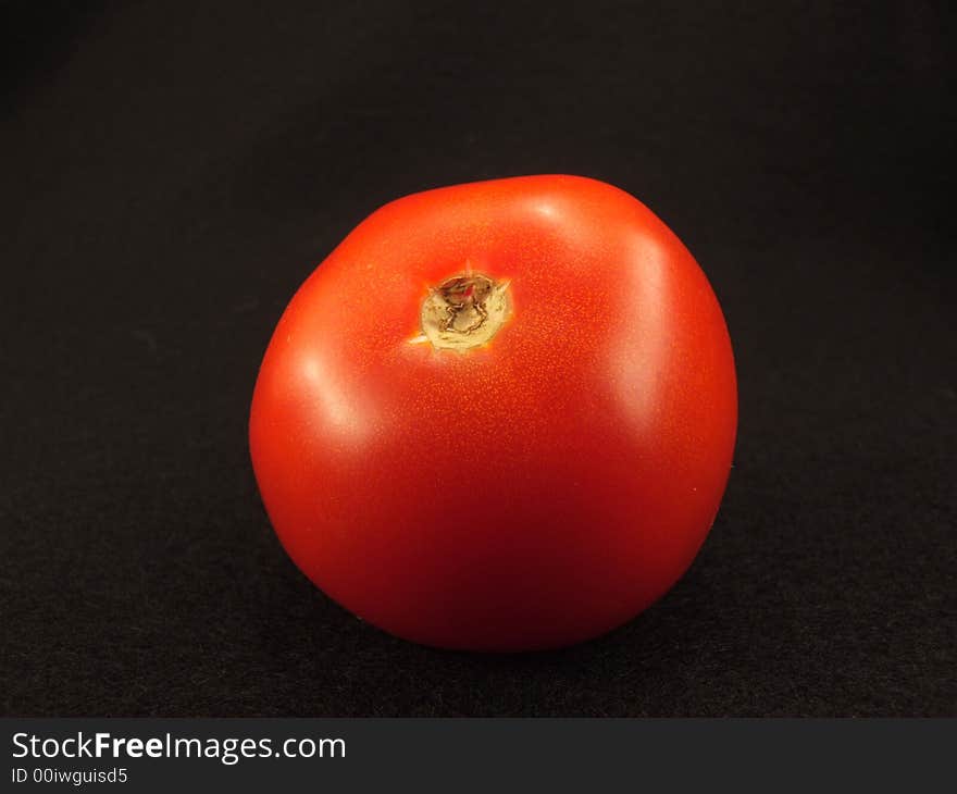 Fresh tomato on black background