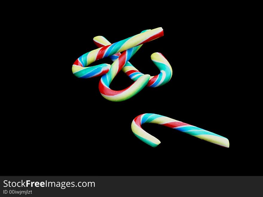 Multicolored candy canes in front of black background. Multicolored candy canes in front of black background.