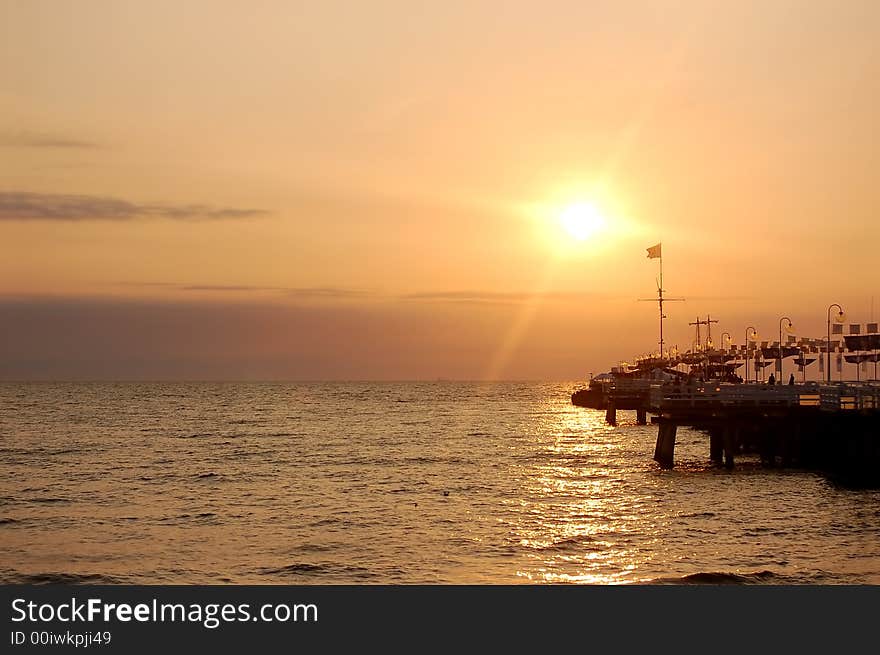 View of sunrise ocean with pier