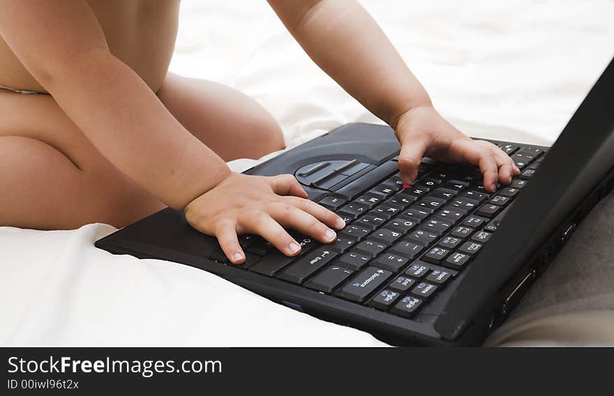 Baby hands close up on computer laptop