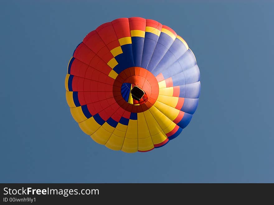 Colourful balloon taking off pictured directly underneath. Colourful balloon taking off pictured directly underneath