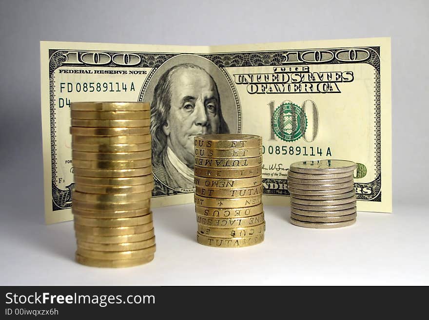 Coins shot on a hundred dollar bill background. Coins shot on a hundred dollar bill background