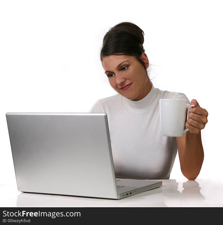 Young woman looks at her laptop computer and drinks her coffee on White Extractable Background. Young woman looks at her laptop computer and drinks her coffee on White Extractable Background